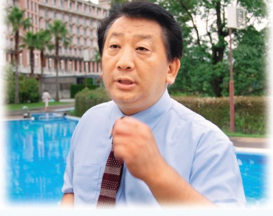 露崎强站在新收购的酒店前接受采访