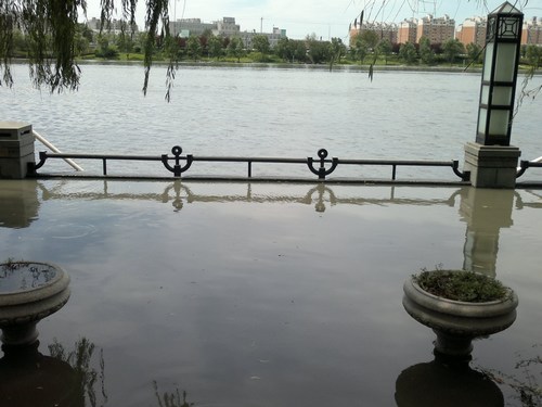 河水已冲上堤岸的步行道，有50公分深，景观灯已被冲毁。